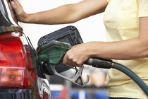 Woman putting gas in car